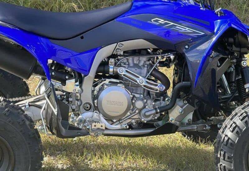 Side View of a Blue Yamaha ATV Highlighting its Exposed Engine and Mechanical Components