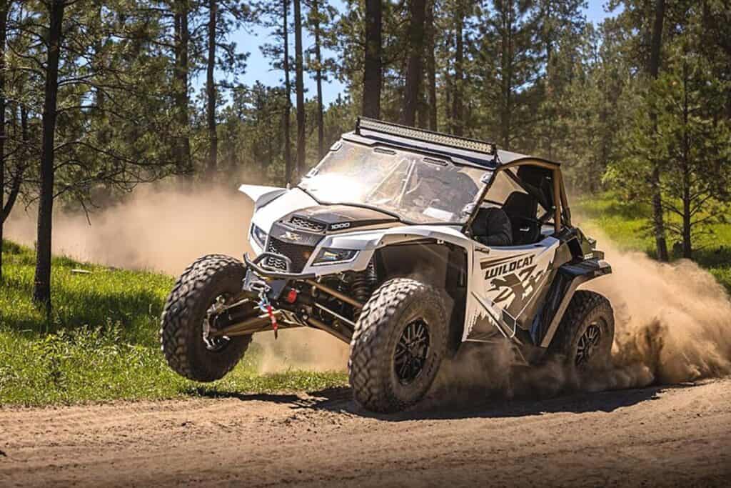 Arctic Cat Wildcat XX Black Hills Edition UTV Aggressively Taking on a Dirt Trail, Kicking Up a Significant Amount of Dust in its Wake