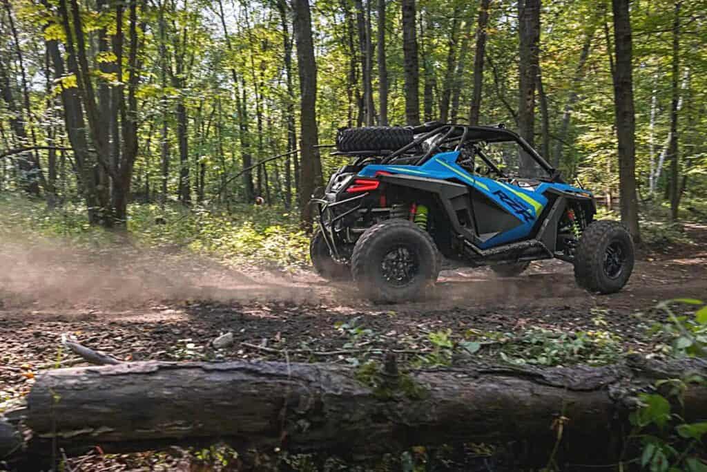 Polaris RZR Turbo R Ultimate UTV Traversing a Forest Trail, as it Leaves a Trail of Dust Behind