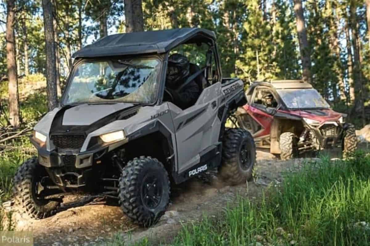 Polaris UTV Leading the Way on a Forest Trail with Another UTV Following Behind