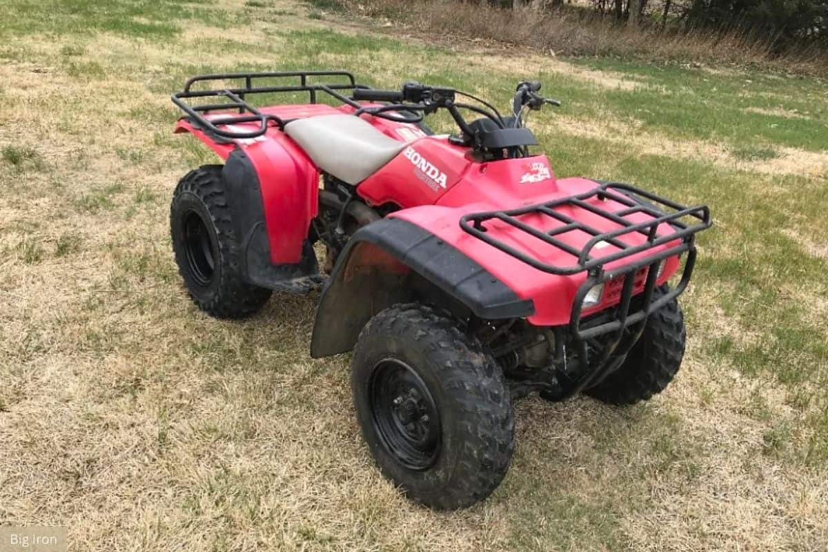 Front right view of a Honda Fourtrax 300 parked in a field.